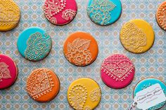 colorful decorated cookies are displayed on a blue and white tablecloth with a name tag