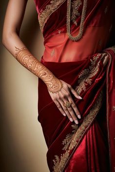 a woman in a red sari with henna on her arm