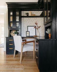 a desk and chair in a room with wooden floors, built - in bookshelves