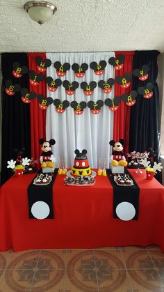 a mickey mouse themed birthday party with red tablecloths and black and white decorations