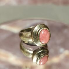 Immerse yourself in the allure of vintage charm with this unique Vintage Tarnished Pink Agate on Sterling Silver Ring. Crafted with a sterling silver setting and adorned with a beautifully weathered pink agate, this ring tells a story of timeless elegance and character. Sized at 8, this vintage piece is ready to add a touch of rustic beauty to your collection. Details: Material: Genuine Sterling Silver Stone: Tarnished Pink Agate Size: Ladies Size 8 Design: Vintage, Tarnished, Rustic Elegance Wh Vintage Oval Moonstone Ring With Polished Finish, Vintage Moonstone Oval Cabochon Ring, Vintage Oval Cabochon Moonstone Ring, Vintage Cabochon Rings For Gifts, Vintage Cabochon Rings As Gift, Handmade Vintage Moonstone Ring, Vintage Brass Jewelry With Natural Stones, Vintage Handmade Adjustable Moonstone Ring, Vintage Adjustable Oval Moonstone Ring