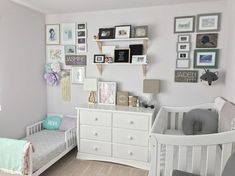 a baby's room with two cribs and pictures on the wall