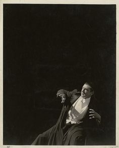 black and white photograph of a man in a suit throwing a frisbee