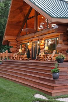 a log cabin with wooden steps leading up to the front door and covered porch area