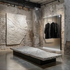 an empty room with brick walls and clothes hanging on the racks in front of it