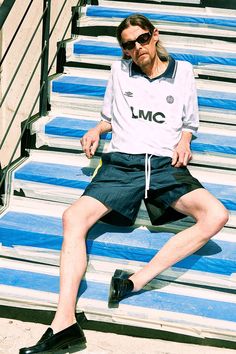 a man sitting on some bleachers with his legs crossed