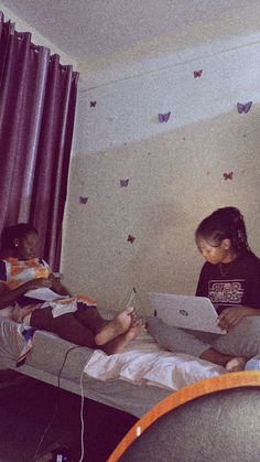 two children are sitting on a bed and one is writing