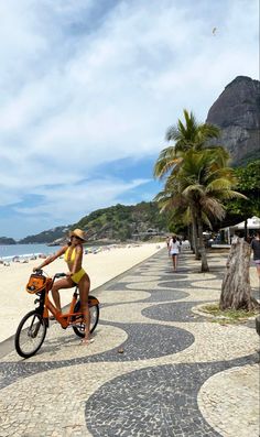 a woman riding a bike on the beach