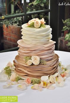 a multi layered cake with flowers on top