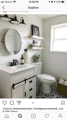 a white bathroom with black and white tile flooring, shelving above the toilet