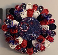 a patriotic wreath with red, white and blue decorations on it next to a framed photo