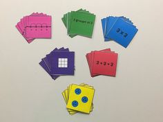 several pieces of colored paper with numbers and fractions on them are arranged in the shape of squares