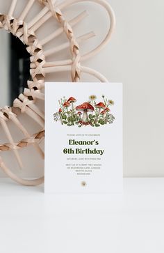 a birthday card sitting on top of a white table next to a wooden chair and wicker basket