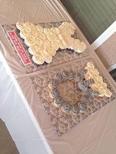 three decorated cakes sitting on top of a table covered in white paper and frosting