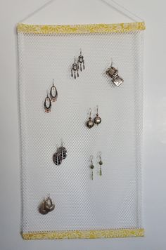 a white wall hanging with earrings on it