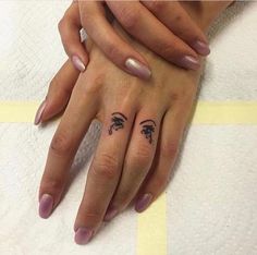 two hands holding each other with tattoos on their fingers and palm trees tattooed on them