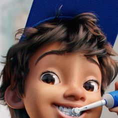 a young boy brushing his teeth with an electric toothbrush while wearing a graduation cap