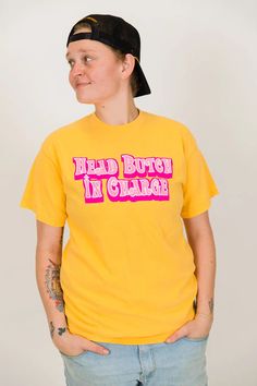 "Head Butch In Charge" screen-printed yellow shirt. Let everyone know who is really in charge with this fun shirt. Pre-shrunk, soft washed, garment dyed fabric Designed and made in New Orleans Unisex sizing Size Chart: (in inches) S M L XL 2XL 3XL Sleeve Length 8 8 ¼ 9 9 ½ 9 ¾ 9 ¾ Full Body Length 27 28 ½ 30 31 ½ 32 ¾ 33 Body Width 18 ½ 20 ½ 22 ½ 24 ½ 26 ½ 28 Fitted Yellow T-shirt With Graphic Print, Yellow Cotton Shirt With Screen Print, Unisex Yellow Graphic Print Top, Fitted Yellow T-shirt With Screen Print, Yellow Shirt With Funny Print And Relaxed Fit, Yellow Shirt With Funny Print In Relaxed Fit, Yellow Graphic Tee Shirt With Screen Print, Yellow Graphic Tee With Screen Print, Relaxed Fit Pre-shrunk Yellow Tops