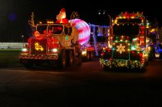 two large trucks decorated with christmas lights at night