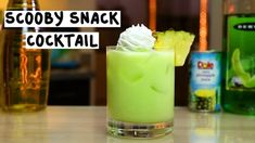 there is a green cocktail with whipped cream on top