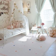 a white room with pink and blue decor on the walls, flooring and curtains