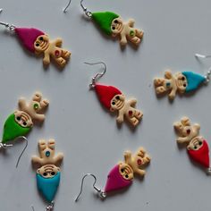 several different colored earrings with small cartoon figures hanging from it's earwires