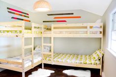 two bunk beds in a small room with wood flooring and walls painted blue, green, yellow and white