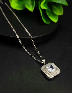 This beautiful square diamond necklace is the perfect way to add a touch of luxury to your outfit. The diamond is set in a simple yet elegant setting that is perfect for any occasion. Whether you're dressing up for a special night out or just want to add a little sparkle to your everyday look, this necklace is a great choice. Classic Pendant Necklaces For Parties, Elegant Diamond Jewelry With Rectangular Stone, Elegant Rectangular Diamond Jewelry, Formal Silver Jewelry With Rectangular Stone, Emerald Cut Cubic Zirconia Jewelry For Party, Emerald Cut Cubic Zirconia Party Jewelry, Classic Clavicle Chain Necklace For Evening, Elegant Formal Diamond Necklace With Clavicle Chain, Diamond Clavicle Chain Necklace For Evening