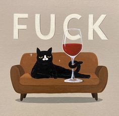 a black cat sitting on top of a couch next to a glass of wine