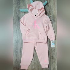 New Little Girl's Calvin Klein 2 Pc. Jogging Set. Soft Fleece Material Elastic At Wrists And Waist Of Hoodie, Elastic Waist On Joggers And Elastic Around Ankles All Light Pink Except Ck Logo, Which Is Neon Pink And White On Front Of Hoodie. No Strings On Hood Large Kangaroo Pocket On Hoodie Nwt Size 24 Mo. Cute With Their Suede Boots, Tennies, Or Slides. Thanks For Stopping By And Please Share If You Don't Buy And Spread The Posh Love. Happy Poshing!!! Pink Cotton Hooded Sets, Hooded Pink Cotton Sets, Formal Boys Outfit, Calvin Klein Set, Hoodie And Joggers, Ck Logo, Tunics With Leggings, Calvin Klein Shorts, Sweatsuit Set