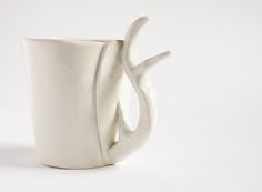 a white ceramic cup with a curved handle