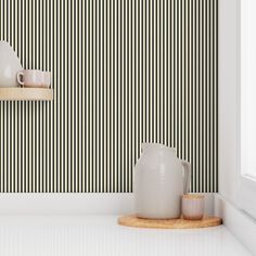 two white vases sitting on top of a counter next to a wall mounted clock