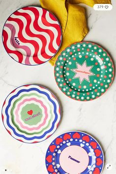 three colorful plates sitting on top of a white marble counter next to a yellow banana