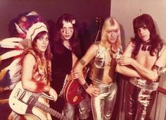 the group of people are dressed in costumes and posing for a photo with their guitars