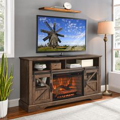 a flat screen tv sitting on top of a wooden entertainment center next to a fire place