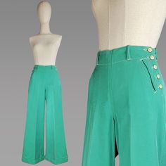 ~ Hard to find 1940s green denim cowgirl pants. ~ High waisted with a wide band and belt loops. ~ Button up sides with standout ivory and green  buttons.  ~ Two side slant smile pockets.  ~ Sewn cuffed hems. ~ Front creasing in pants.  Size - Small  Waist - 28" Hip - 40" Length - 37" Inseam - 27" Label: Made By Dickson - Jenkins MFG Co. FT. Worth Texas Condition: Excellent vintage condition. Very faint wear on the back top right of the waistband. Very hard to see and photograph All vintage is sold in "as-is" condition. We do our best to inspect, correct, and list important flaws. All measurements are made with the garment laying flat. Length is measured from shoulder to hem unless otherwise noted. Color is described as closely as possible. Be aware that monitors show color differently. Mes Side Button Pants, Cowgirl Pants, 1970s Pants, Turquoise Pants, Ft Worth Texas, Denim Cowgirl, Western Pants, Button Pants, Ranch Wear