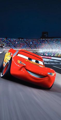 the character from cars is driving in front of a stadium full of spectators at night