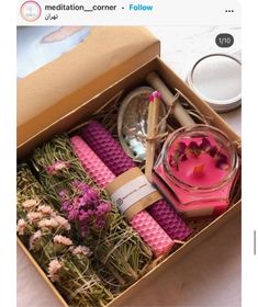 a box filled with candles and flowers on top of a white tablecloth next to other items