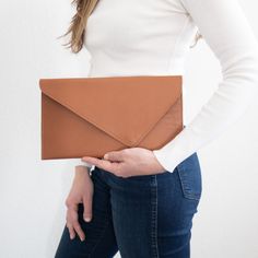 a woman is holding an envelope in her right hand and the bottom half of her body