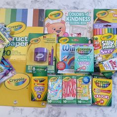 various school supplies laid out on a marble counter top, including crayons, markers and pencils