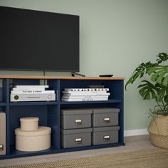 an entertainment center with several storage bins and a flat screen tv