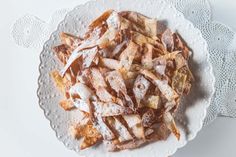 a white plate topped with apple slices covered in powdered sugar