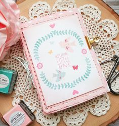 an open notebook sitting on top of a doily next to some scissors and other items