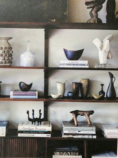 shelves with vases, books and sculptures on them