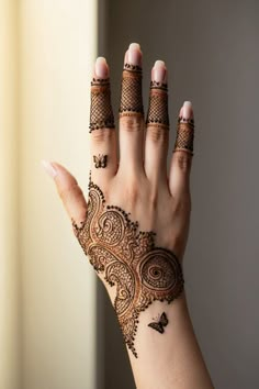 a woman's hand with henna tattoos on it