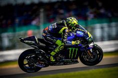 a man riding on the back of a motorcycle down a race track