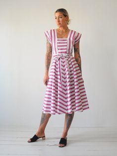 "Vintage 80's chevron striped sundress. Adjustable tie at waist. Open back with buttons down lower back. Full skirt. Lightweight cotton material. - - M E A S U R E M E N T S - - Fits like: xs/small Bust: 17\" Waist: 13\"-adjustable smaller Length: 44\" Hips: open Shoulder: 14.5\" Fabric: cotton In excellent condition - no flaws to note. ● Model is 5'7\" / bust: 34\" / waist: 25\" / hips: 37\"" Vintage Striped Summer Dresses, Striped Cotton Summer Sundress, Cotton Summer Dress With Vertical Stripes, Striped Sundress, Batman T Shirt, College Sweatshirt, Chevron Stripe, Light Wash Jeans, Lower Back