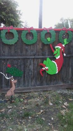 a fence decorated with christmas decorations and an image of the grin on it's side