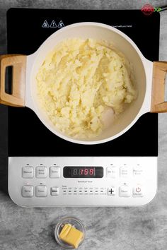 mashed potatoes in a white bowl on top of an electric stove