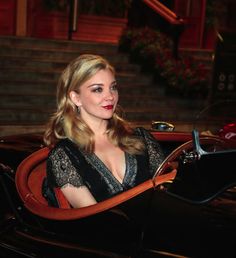 a woman sitting in a black car at night